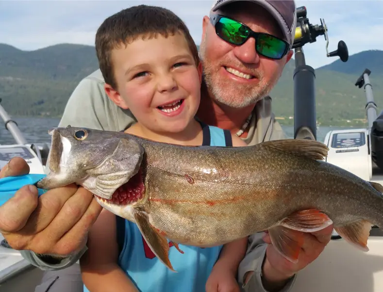 Captain Mike and a young angler proudly holding up a fish on Flathead Lake